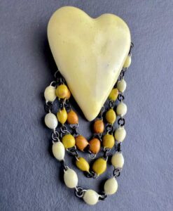 Superbe broche en céramique formée d'un gros coeur jaune pale et trois rangs de perles en 3 jaunes dégradés. Fait main en France