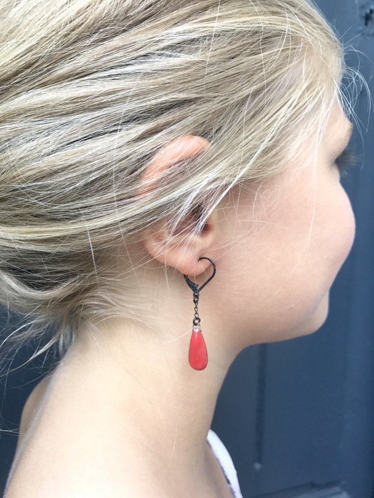 Les boucles d'oreilles Joséphine portées en rouge fort.