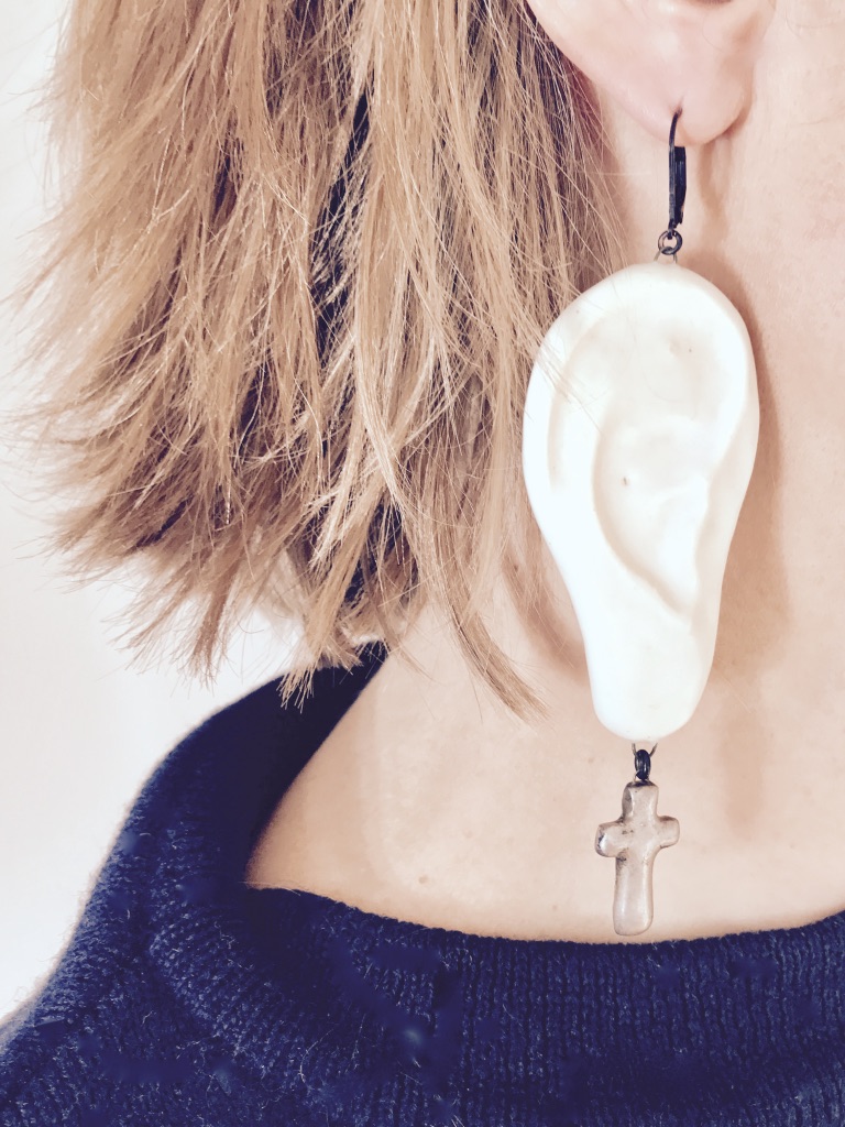 Boucles d'oreilles en céramique mate en forme d'oreilles portant une boucle d'oreille croix argentée