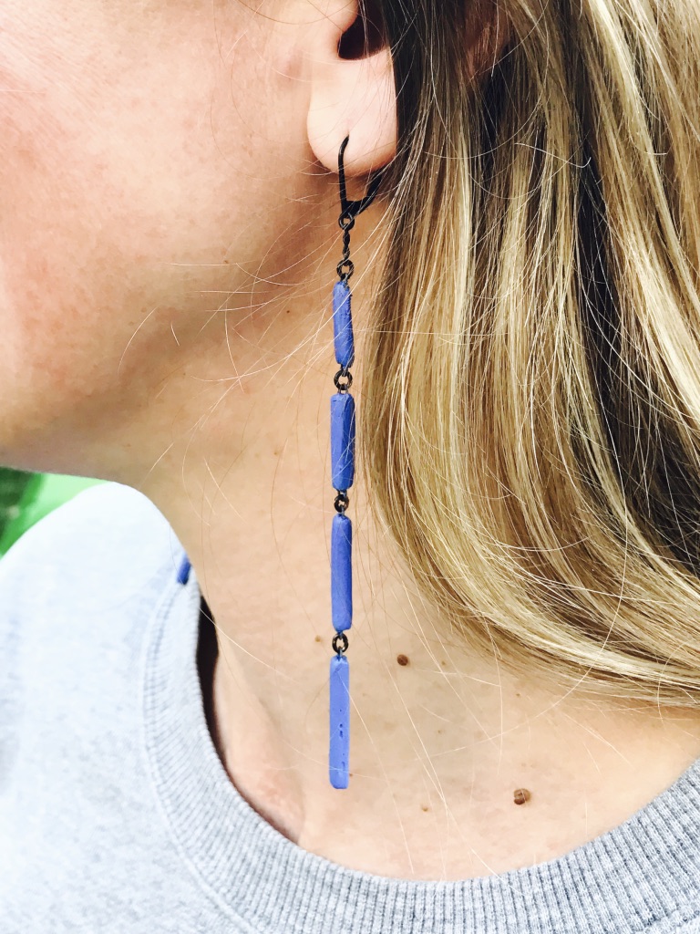 Graphic earrings as a set of thin blue rectangular ceramic elements