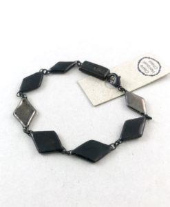 Bracelet sobre et chic formé de losanges noir et platine en céramique liés les uns aux autres.
