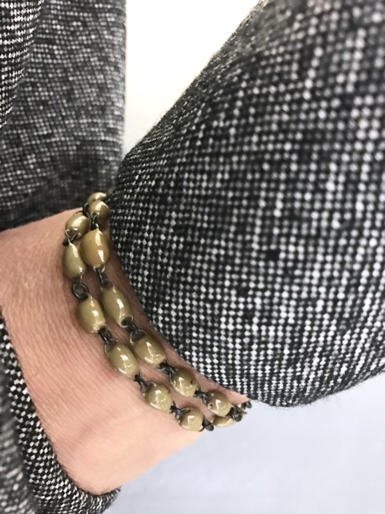 Un bracelet en céramique très fin, formé de deux rangs réunis par une mini perle plate, signature estampillée sur une pampille, fait main en France.