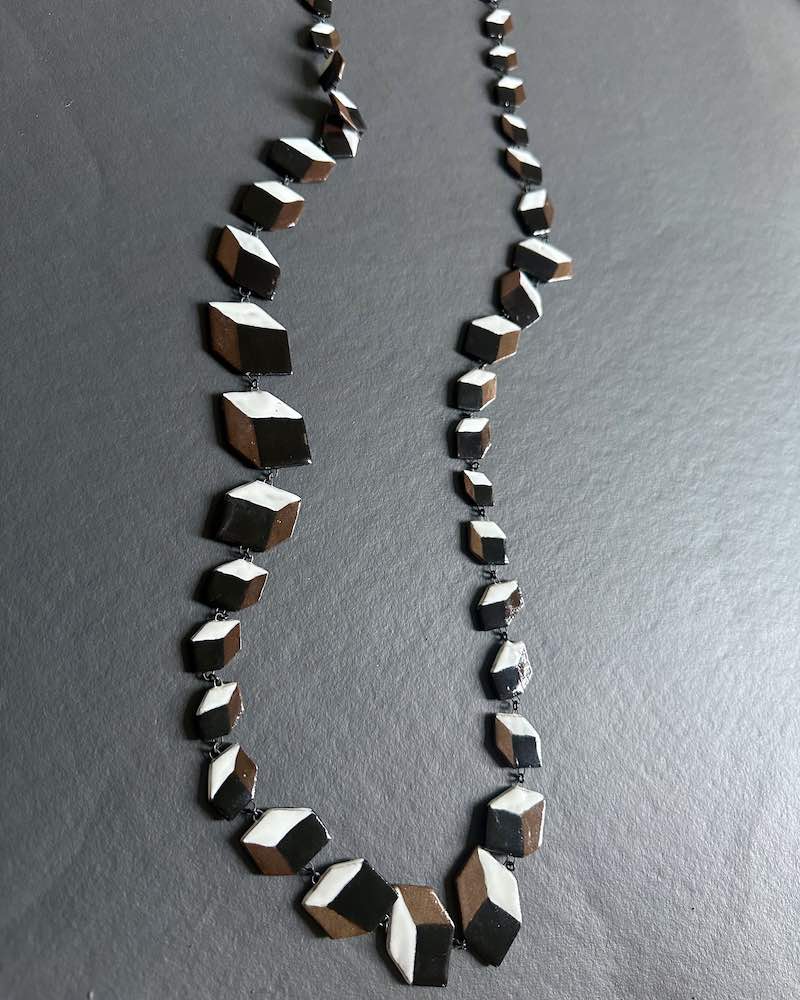Sautoir long en céramique spectaculaire fait d une trentaine de cubes plats en trompe l'œil.