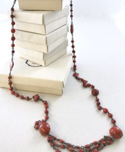 A ceramic chain made of small marbles like beads alternated with clin d'oeil details and ended by three beads lines