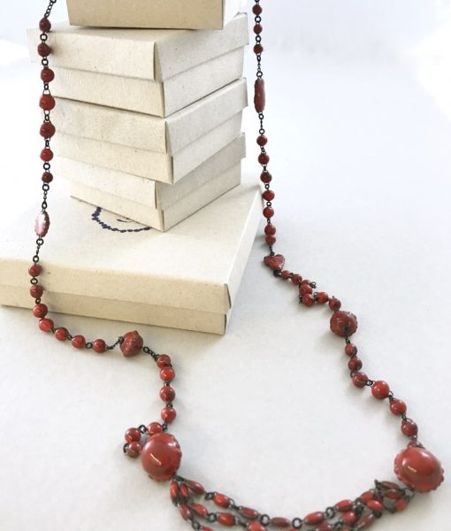 A ceramic chain made of small marbles like beads alternated with clin d'oeil details and ended by three beads lines