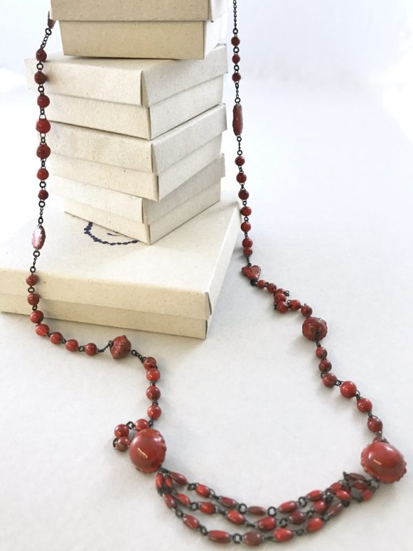 A ceramic chain made of small marbles like beads alternated with clin d'oeil details and ended by three beads lines