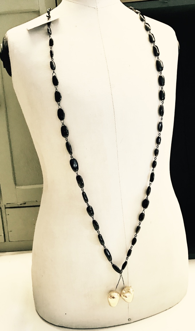 Sautoir long simple et chic formé de perles en céramique noires ou blanches et de deux cerises or ou rouge, fait main en France par Claire Hecquet-Chaut