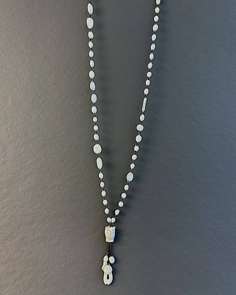 Collier fluide et mystérieux constitué de deux lignes de fines perles en céramique et une mini chouette suspendue a son extremité